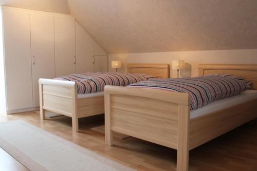 two beds in a bedroom with white cabinets at Emsland-Quartier in Bawinkel