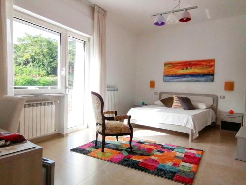 ein Schlafzimmer mit einem Bett, einem Stuhl und einem Teppich in der Unterkunft Feudo di Castelmozzo in Santa Paolina