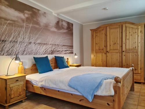 a bedroom with a large bed with blue pillows at LandGang in Vadersdorf
