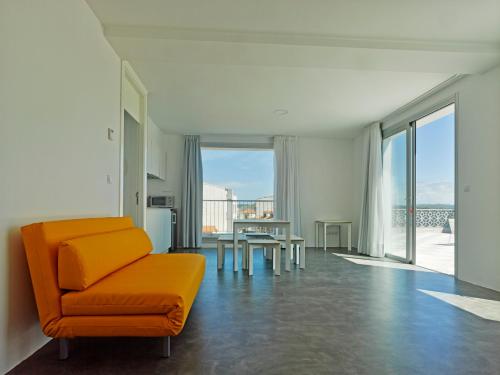 a living room with an orange chair and a table at Bela Muxía in Muxia