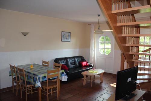 ein Wohnzimmer mit einem schwarzen Ledersofa und einem Tisch in der Unterkunft Ferienwohnung 2 Struven Hus in Lehe