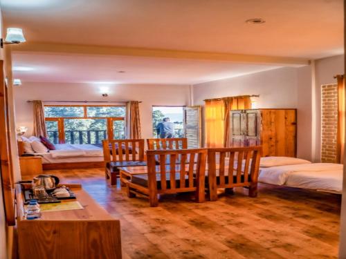 a bedroom with two beds and a table and benches at LA Riqueza Kanatal #Prime Location # Big Parking # Top Selling # Mountain View Rooms in Kanatal