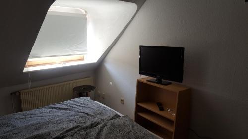 1 dormitorio con cama y vestidor con TV en Charmante Wohnung im Stadtkern, St Wendel, en Sankt Wendel