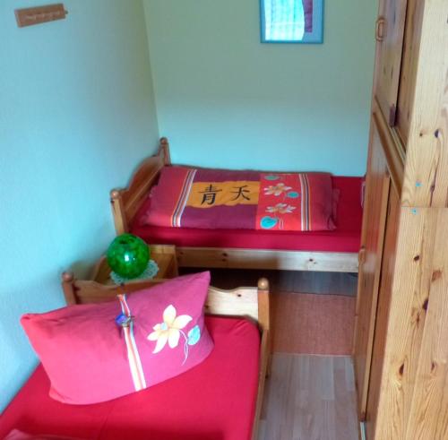 a room with two beds and a red couch at Wohnung Nr 2 in Haffkrug