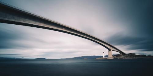 een brug over een waterlichaam met een vuurtoren bij Isle of Skye Guest House in Kyleakin