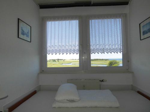 a room with a window with a bed in front of it at Fewo " fáros " in Heiligenhafen