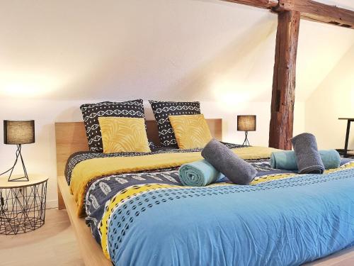 um quarto com uma cama com um edredão azul e amarelo em ✪ Le Convivial ✪ Duplex Alsacien ✪ PARKING ✪ RBNB✪ em Turckheim