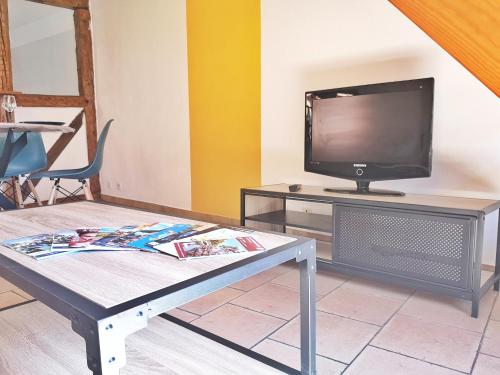 a living room with a table and a tv at ✪ Le Convivial ✪ Duplex Alsacien ✪ PARKING ✪ RBNB✪ in Turckheim