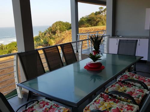 una mesa y sillas en un balcón con vistas al océano en Westbrook Cabanas 4, en Westbrook