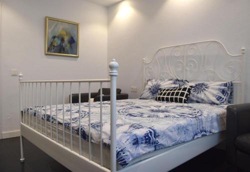 ein weißes Bett mit einer blauen und weißen Bettdecke in der Unterkunft Casa Green in Mijas Costa