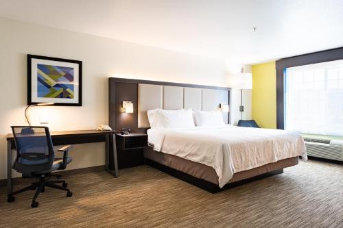 a hotel room with a bed and a desk and a chair at Holiday Inn Express Hotel & Suites Evanston by IHG in Evanston