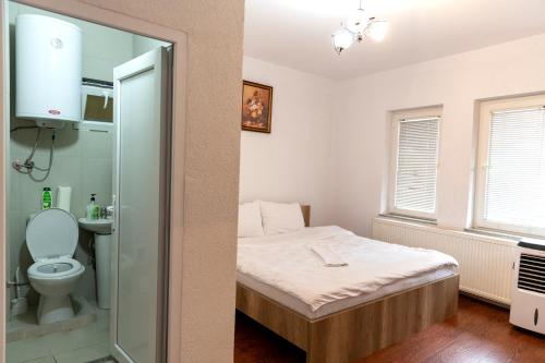 a small bedroom with a bed and a toilet at Hotel Park in Prishtinë