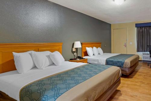 a hotel room with two beds and a window at Econo Lodge in Pryor