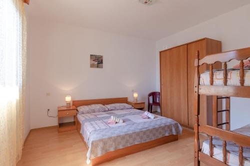 ein Schlafzimmer mit einem Bett und einem Etagenbett in der Unterkunft Seafront Apartments Olivera in Blato