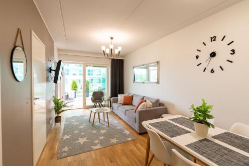 sala de estar con sofá y reloj en la pared en StarHomes Double lux 7, en Oulu