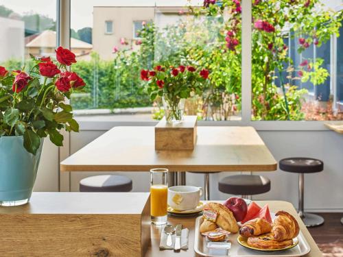 a table with a plate of pastries and orange juice at ibis budget Santeny in Santeny