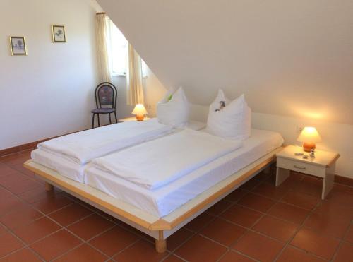 a bedroom with a large bed with white sheets and pillows at Ferienparadies Rugana A09 in Kreptitz