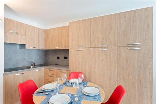a kitchen with a table with red chairs and a dining room at Gressoney Saint-Jean apartments by Halldis in Gressoney-Saint-Jean