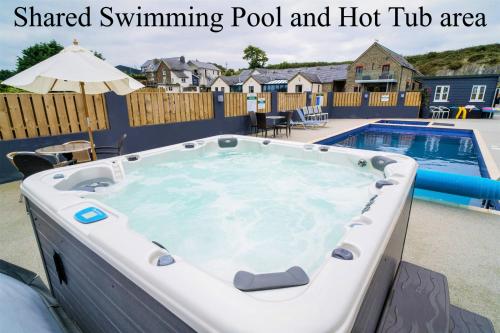a swimming pool with a hot tub in a backyard at The Barn in Aberystwyth