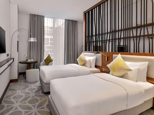 Grand Mercure Dubai City tesisinde bir odada yatak veya yataklar