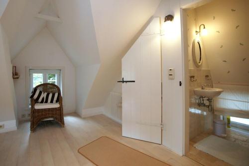 an attic bathroom with a sink and a toilet at Witje Hüs in Boldixum