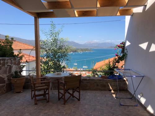 a patio with a table and chairs and a view of the water at VERANDA BLUE - POROS in Poros