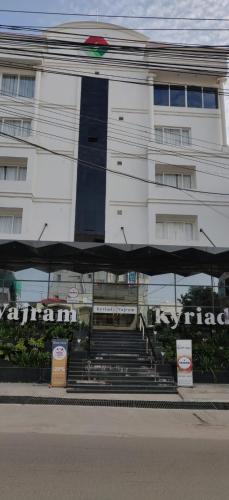 Un edificio blanco con escaleras al frente. en Kyriad Vajram Guntur, en Guntūr