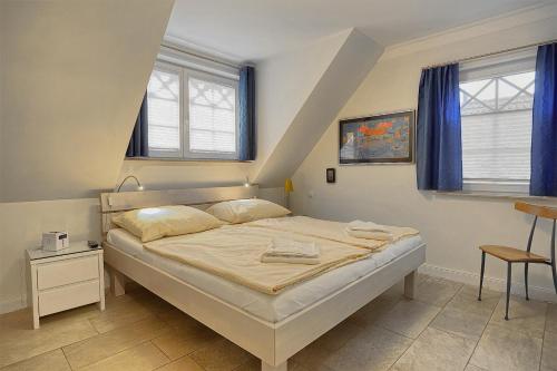 ツィングストにあるLes Belles, Haus Davide, FW Mondain, Whg 10のベッドルーム1室(青いカーテン付きの大型ベッド1台付)