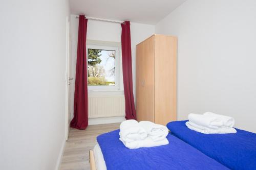 a room with two beds with towels on them at Schleiblick App 2 in Rabenkirchen-Faulück