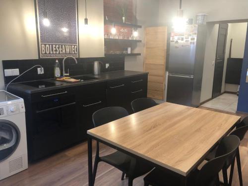 a kitchen with a wooden table and a refrigerator at apartament Śródmieście 1 sypialnia oraz 1 salon in Wałbrzych