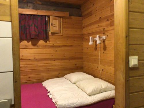 a sauna with a bed in the corner of a room at Petäjälammen Turistimajat in Kuusamo