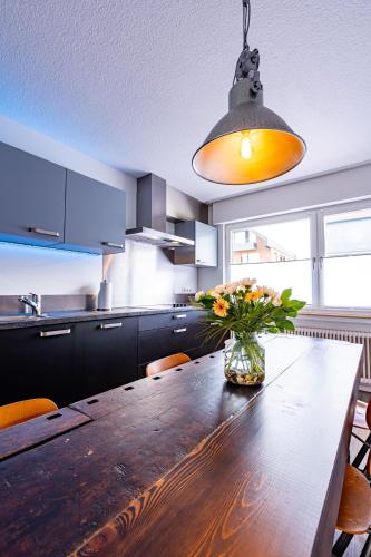 a kitchen with a wooden table with a vase of flowers at Architektenwohnungen mit Panoramablick bei Köln in Lindlar