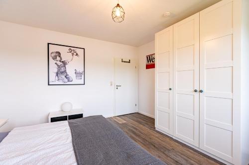 a bedroom with a bed and a closet at Architektenwohnungen mit Panoramablick bei Köln in Lindlar