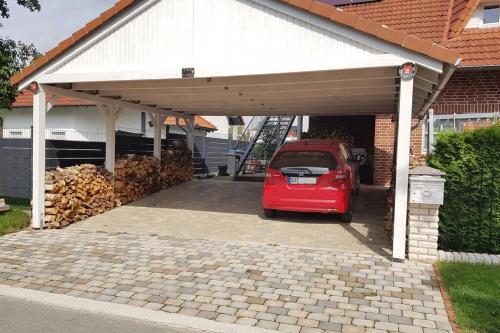 a red car is parked under a garage at Haus Soestblick - Ferienwohnung in Möhnesee