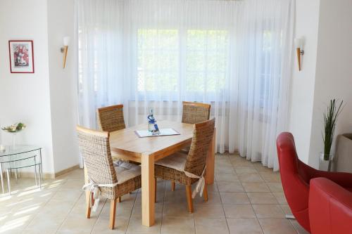 ein Esszimmer mit einem Holztisch und Stühlen in der Unterkunft Haus Birnbaum in Zingst