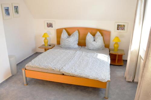 a bedroom with a bed with white sheets and pillows at Haus Birnbaum in Zingst