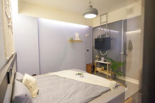 ein kleines Schlafzimmer mit einem Bett und einem Fernseher in der Unterkunft Haus Inn in Taitung