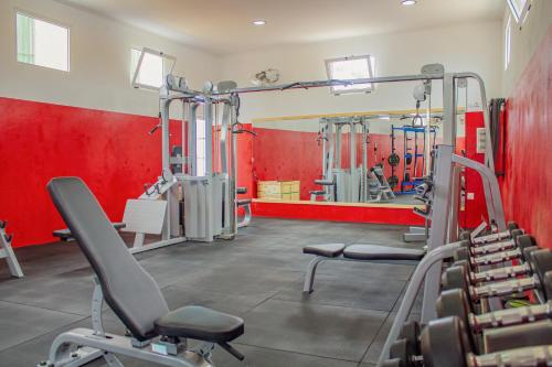a gym with two tread machines and red walls at Hotel Vitoria in São Tomé