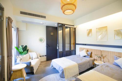ein Hotelzimmer mit zwei Betten und einer Couch in der Unterkunft Haus Inn in Taitung