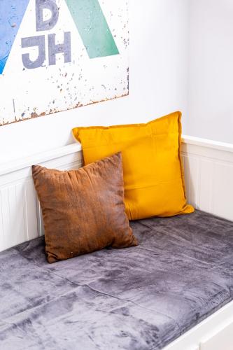 a couch with two pillows on it next to a wall at Architektenwohnungen mit Panoramablick bei Köln in Lindlar