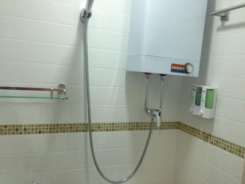 a shower in a bathroom with a water tank at C U Again Hostel in Hong Kong