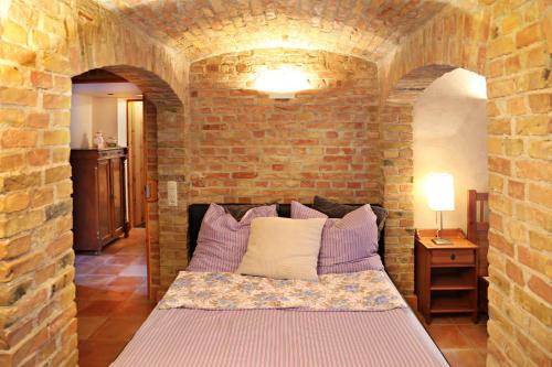 a bedroom with a bed in a brick wall at Souterrain in Potsdam