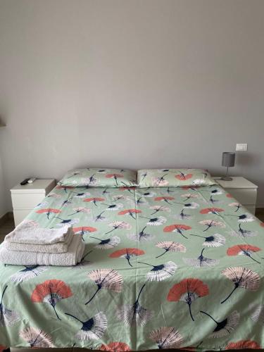 a bed with a green comforter with drawings of butterflies at Tres joli in Rome