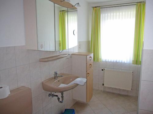 a bathroom with a sink and a mirror and a window at "Landhaus Voss" Typ 3 Nr9 in Staberdorf