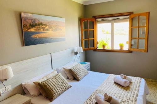 1 dormitorio con cama con almohadas y ventana en 2 Apartments with private pool at Villa Diaz Aleman, en Salobre