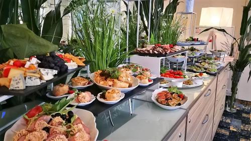 a buffet with many plates of food on a table at Green Garden Hotel in Raszyn
