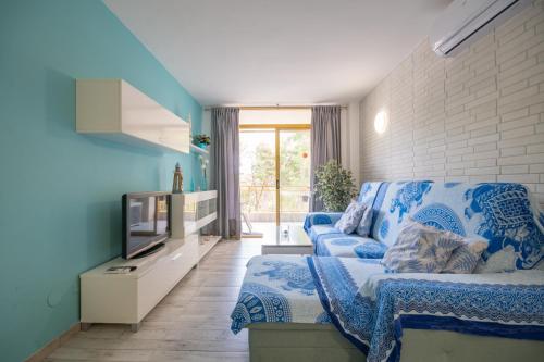 Sala de estar azul con sofá y TV en Salou-Piscina-Playa Port Aventura1, en Salou