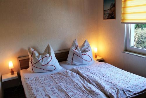 a bedroom with a bed with white sheets and pillows at Blaues Haus mit Meerblick in Hohenkirchen