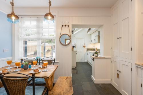 a kitchen and dining room with a wooden table and chairs at Robin Hood's Bay Coastguard's Cottage with a View in Robin Hood's Bay