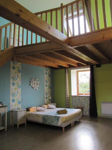 - une chambre avec un lit et un escalier en bois dans l'établissement Chambres d'hôtes de la Becterie, à Quettetot